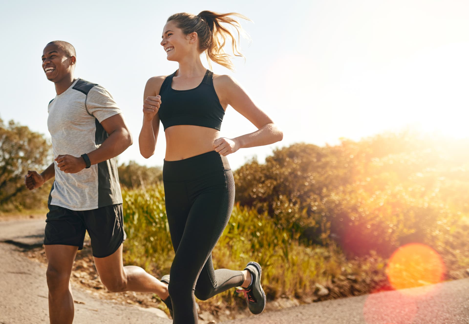 Couple jogging together on a sunny trail